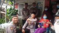 Kapolres Garut AKBP Wirdhanto Hadicaksono, menyerahkan satu unit kursi roda dan uang 'kadeudeuh' dalam program rutin 'Jumat Berkah' polres Garut. (Liputan6.com/Jayadi Supriadin)