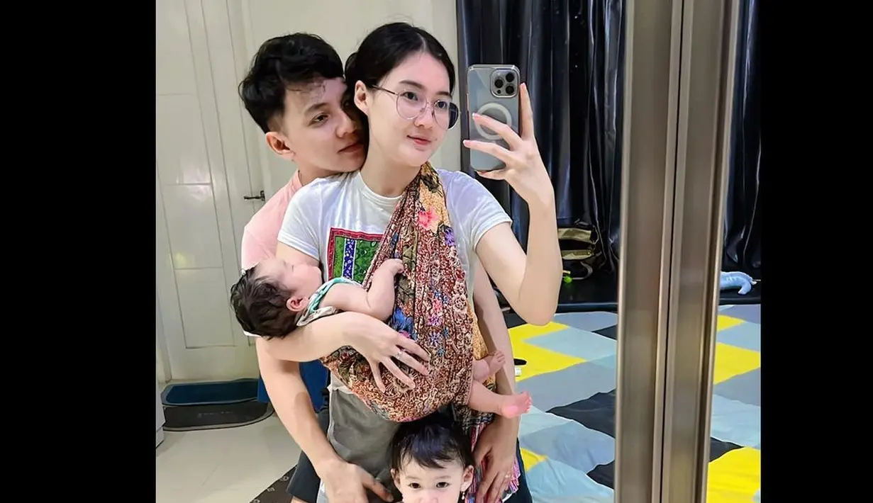 <p>Mengenakan celana pendek dengan kaos. Nella pun menggendong Kenes Nara Madaharsa dengan kain jarik. Wanita berusia 29 itu menikmati perannya sebagai dua orang ibu. Sang suami juga kerap membantunya dalam mengasuh anak-anak. [Instagram/nellakharisma]</p>