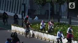 Warga bersepeda di kawasan Bundaran, Hotel Indonesia, Jakarta, Minggu (20/3/2022). Warga mulai ramai beraktifitas olahraga saat Jakarta kembali menerapkan kebijakan PPKM level 2. (Liputan6.com/Herman Zakharia)