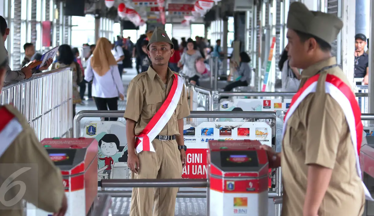 Petugas Trans Jakarta mengenakan pakaian tentara perjuangan tempo dulu di Halte Trans Jakarta, Selasa (16/8). Memperingati HUT RI Ke-71, koridor Trans Jakarta dihiasi nuansa kemerdekaan. (Liputan6.com/Angga Yuniar)