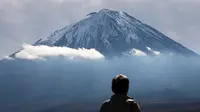 Seorang turis melihat Gunung Fuji dari Fujikawaguchiko, Prefektur Yamanashi, Jepang (1/11). Gunung Fuji adalah gunung tertinggi di Jepang, terletak di perbatasan Prefektur Shizuoka dan Yamanashi, di sebelah barat Tokyo. (AFP Photo/Behrouz Mehri)