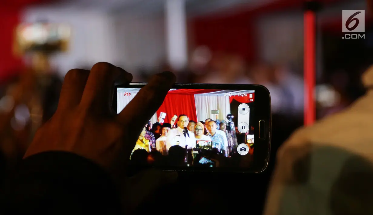 Warga merekam pidato Gubernur DKI Jakarta Anies Baswedan di Balai Kota, Senin (16/10). Anies Baswedan berpidato untuk pertama kalinya sebagai Gubernur DKI Jakarta periode 2017-2022. (Liputan6.com/Faizal Fanani)
