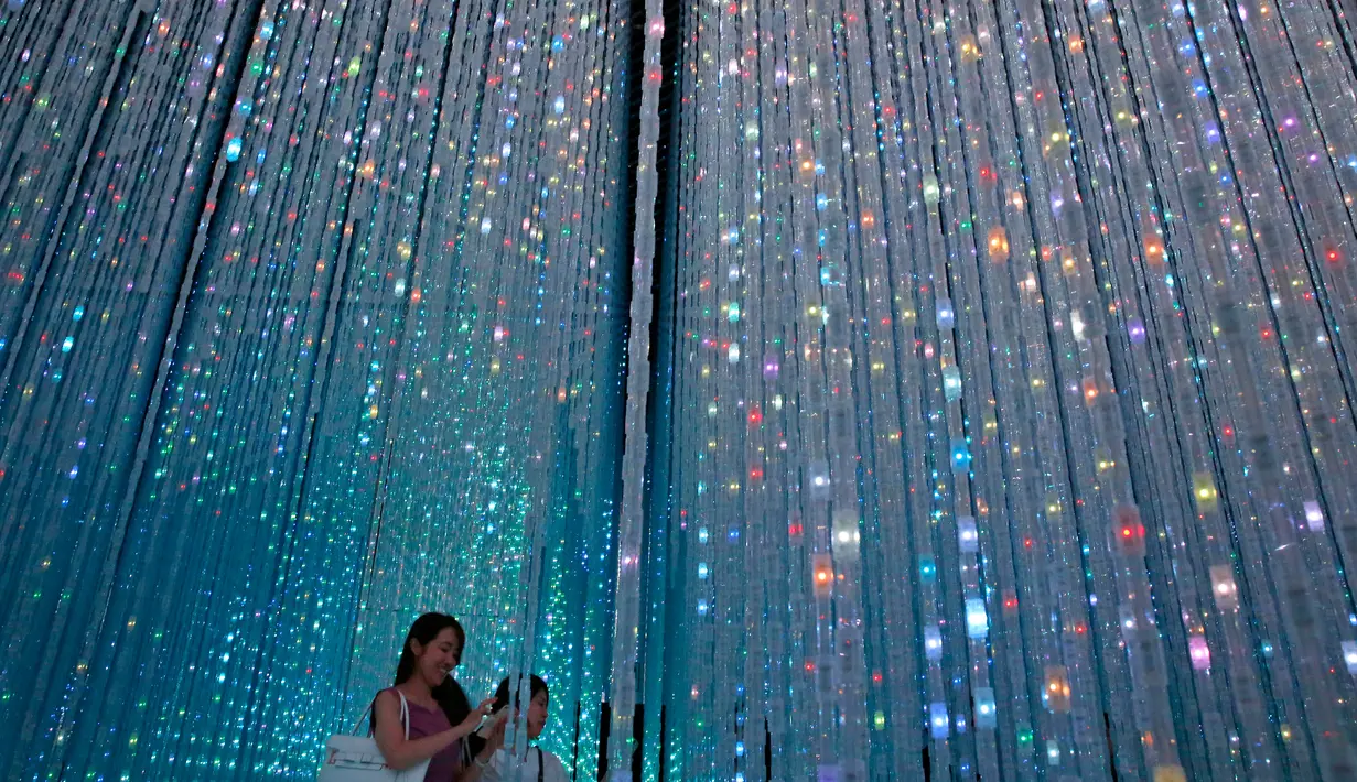 Pengunjung melintasi instalasi "Wander though the Crystal World" di Museum Seni Digital Mori Building, Tokyo, 21 Juni 2018. Selain karya seni, museum ini juga menyuguhkan area panjat dinding yang dipadukan dengan karya seni digital. (AP/Shuji Kajiyama)