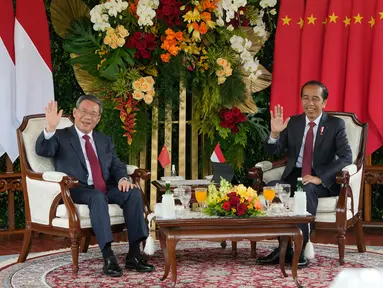 Presiden Republik Indonesia Joko Widodo atau Jokowi (kanan) dan Perdana Menteri China Li Qiang (kiri) melambaikan tangan kepada wartawan saat pertemuan mereka di Istana Merdeka, Jakarta, Indonesia, Jumat (8/9/2023). (AP Photo/Achmad Ibrahim)