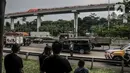 Warga menyaksikan kondisi rangkaian kereta Light Rail Transit (LRT) Jabodebek usai kecelakaan di kawasan Munjul, Cibubur, Jakarta, Senin (25/10/2021). Belum diketahui penyebab tabrakan tersebut dan hingga kini petugas masih menjaga di area kecelakaan. (merdeka.com/Iqbal S Nugroho)