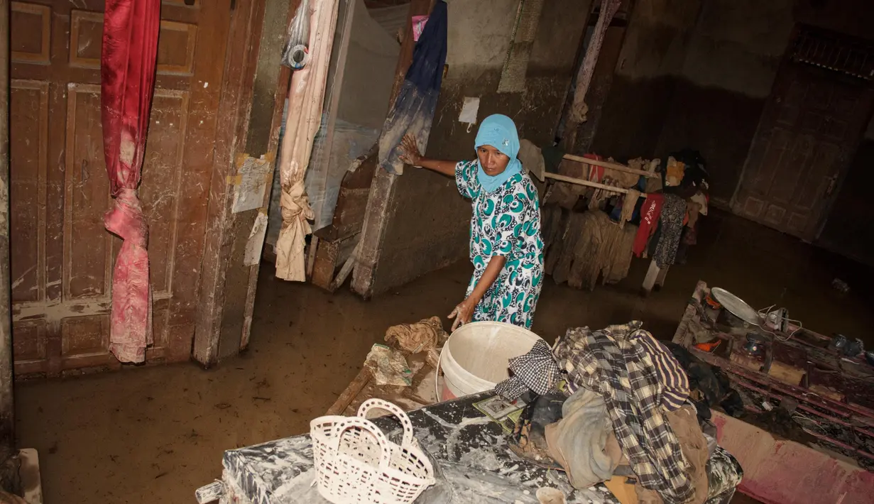 Hingga Sabtu 15 Maret 2025, warga masih kesulitan melakukan pembersihan lokasi tempat tinggal mereka dikarenakan banyak material yang terbawa saat banjir terjadi. (REZAN SOLEH/AFP)