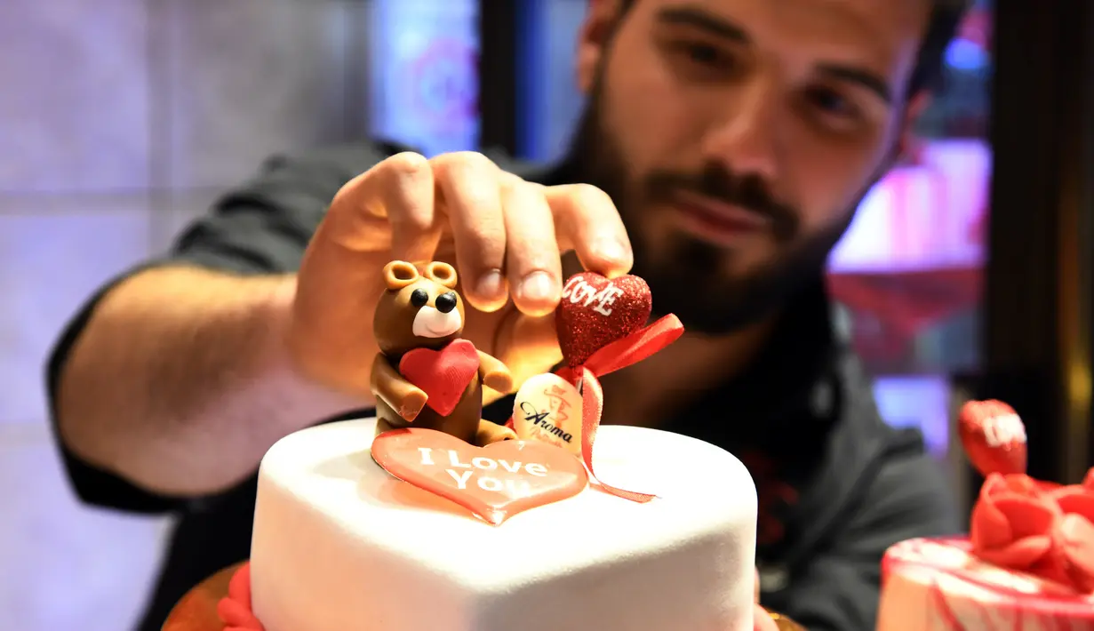 Pembuat kue memberikan sentuhan akhir pada sebuah kue berbentuk hati pada momen Hari Valentine di Damaskus, Suriah, Rabu (12/2/2020). (Xinhua/Ammar Safarjalani)