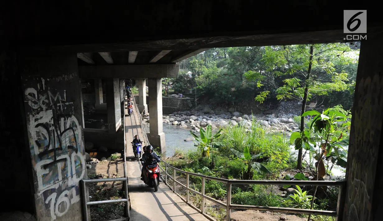 Pengendara motor melewati jembatan Ciliwung yang berada di bawah tol ruas Gadog, Ciawi, Bogor (16/68). Jembatan ini menjadi jalan alternatif bagi pemotor untuk menghindari kemacetan lalu lintas. (Merdeka.com/Arie Basuki)