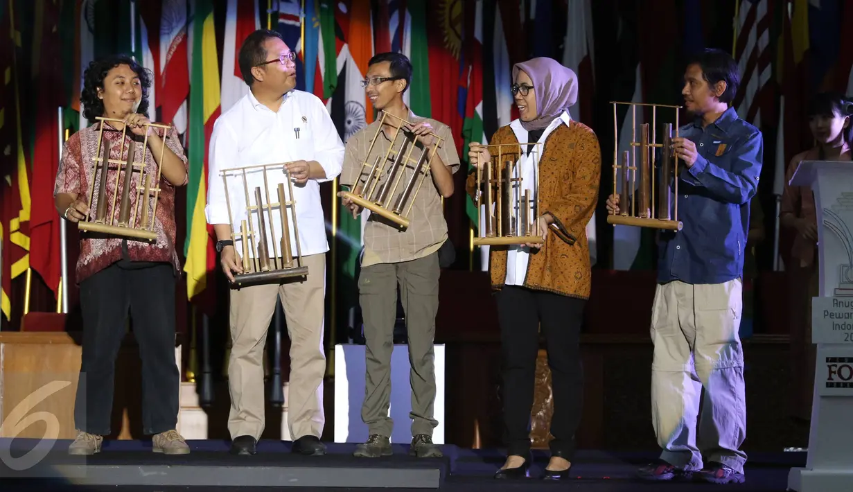 Menteri Komunikasi dan Informatika (Menkominfo) Rudiantara (kedua kiri) memainkan angklung sebagai simbolis pembukaan Anugerah Pewarta Foto Indonesia (APFI) 2016 di Gedung Merdeka, Bandung, Sabtu (9/4). (Liputan6.com/Immanuel Antonius)
