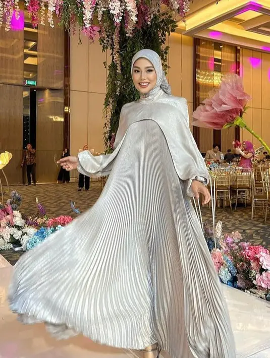 Dress plisket warna silver dipadukan cape lengan panjang warna serasi serta kerudung bermotif agar tampilan tidak monoton. [@daraarafah]
