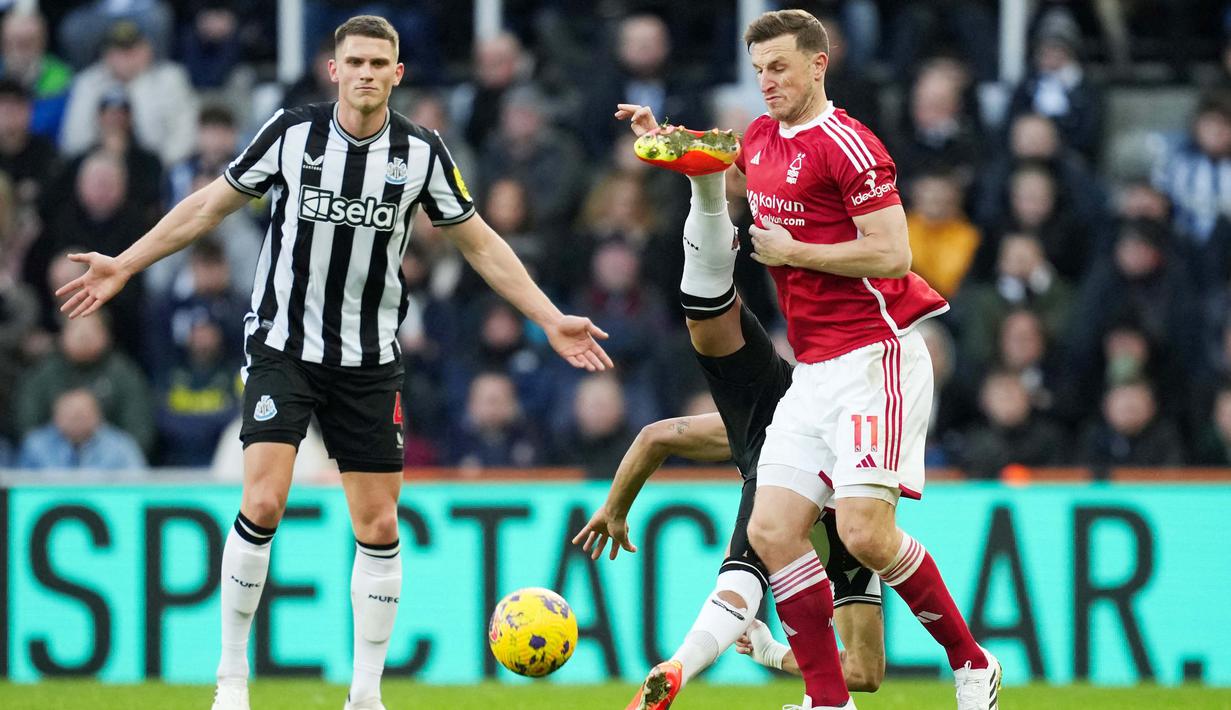 Pemain Nottingham Forest, Chris Wood, berebut bola dengan pemain Newcastle United, Joelinton, dalam lanjutan Liga Inggris di St James Park, Selasa (26/12/2023). Apesnya lagi aktor kekalahan The Magpies adalah mantan pemainnya sendiri yakni Chris Wood. (AFP/Andu Buchanan)