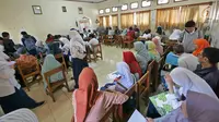 Suasana saat para siswa dan orangtua murid mengikuti seleksi Penerimaan Peserta Didik Baru (PPDB) di SMAN 1 Depok, Kota Depok, Jawa Barat, Selasa (18/6/2019). PPDB SMA dibagi menjadi tiga jalur yakni zonasi, prestasi, dan pemindahan orangtua. (Liputan6.com/Herman Zakharia)