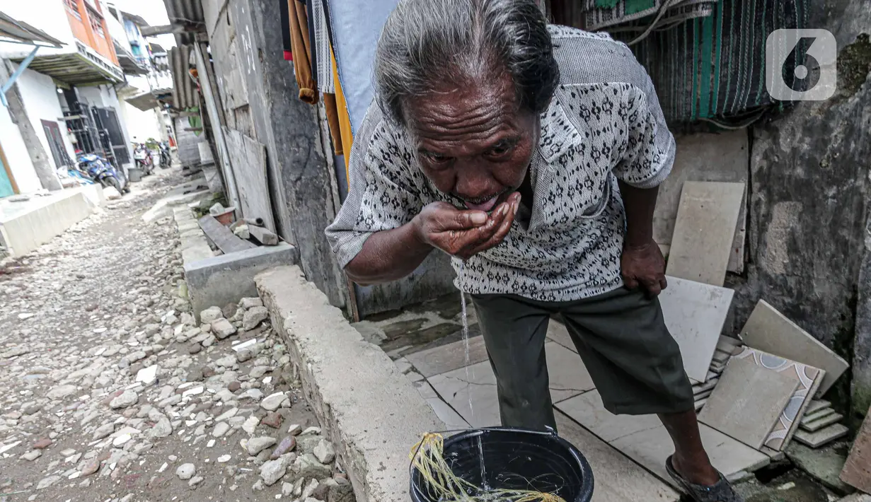 Seorang warga meminum air di kawasan Muara Angke, Jakarta, Sabtu (26/2/2022). Sejak tahun 1980-an, warga Muara Angke, Jakarta Utara, mengalami kesulitan mendapatkan air bersih. (Liputan6.com/Faizal Fanani)