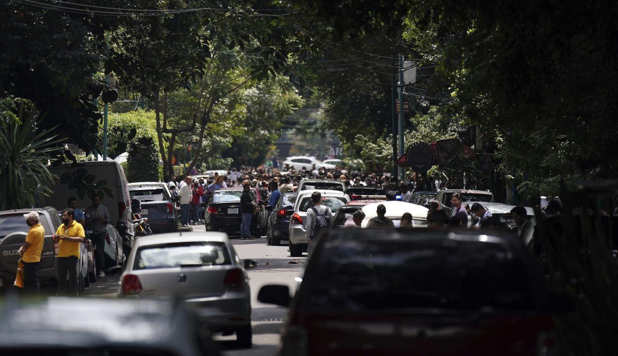 Orang-orang berkumpul di luar setelah merasakan gempa bumi bermagnitudo 7,6 di Mexico City, Senin (19/9/2022).  Alarm gempa Mexico City berbunyi kurang dari satu jam setelah ibu kota mengadakan latihan darurat bencana. Orang-orang langsung tumpah ke jalan lagi. (AP Photo/Fernando Llano)