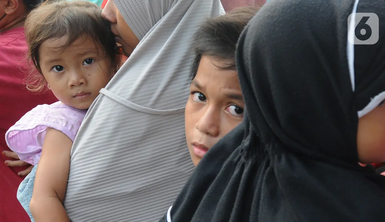 Anak-anak ikut antre mendapatkan takjil di depan Kantor Pemerintah Daerah Kabupaten Bogor, Cibinong, Minggu (17/4/2022). Setiap hari selama bulan Ramadhan Pemkab Bogor menyediakan sekitar 400 hingga 500 paket takjil yang berasal dari dinas- dinas di lingkungan Pemkab Bogor (merdeka.com/Arie Basuki