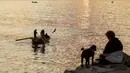 Seorang wanita bersama anjingnya menikmati matahari terbenam di tepi laut Mediterania, Dbayeh (5/12/2019). Pada masa lalu, laut ini merupakan jalur lalu lintas yang sibuk, memungkinkan perdagangan dan pertukaran budaya antara orang Mesir, Yunani Kuno, Romawi Kuno dan Timur Tengah. (AFP/Josep Eid)