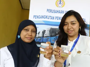 Petugas menunjukan hasil tes urine di Pool Bus Perum PPD (Perusahaan Umum Pengangkutan Penumpang Djakarta) Tangerang Selatan, Senin (20/3). Sosialisasi dan test urine oleh digelar oleh Badan Narkotika Nasional (BNN) RI. (Liputan6.com/Helmi Afandi)
