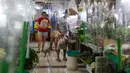 Orang-orang berbelanja di sebuah pasar dengan tirai plastik di kios mereka di kota Quezon, Filipina, Selasa (22/9/2020). Presiden Filipina Rodrigo Duterte mengatakan telah memperpanjang status masa darurat virus corona (Covid-19) di negaranya hingga satu tahun ke depan. (AP Photo/Aaron Favila)