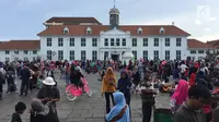 Wisatawan menikmati suasana kawasan Kota Tua, Jakarta, Jumat (16/2). Objek wisata sejarah Kota Tua menjadi salah satu tujuan warga Jakarta dan sekitarnya untuk mengisi libur Tahun baru Imlek 2018. (Liputan6.com/Immanuel Antonius)