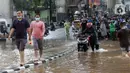 Pengendara mendorong sepeda motornya melewati banjir yang menggenangi kawasan Jalan Wolter Monginsidi Jakarta dan sekitarnya, Sabtu (20/2/2021). Hujan yang mengguyur Jakarta sejak Jumat (19/2) membuat sejumlah titik di Jakarta terendam banjir. (Liputan6.com/Helmi Fithriansyah)
