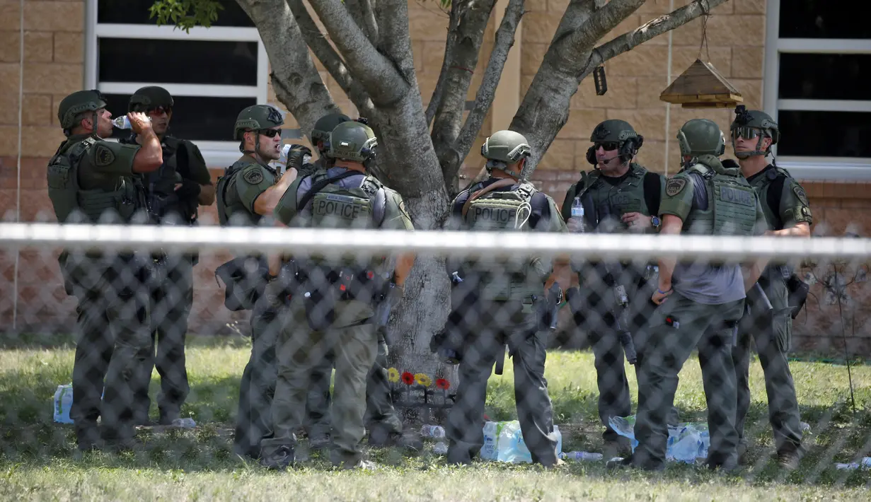 Aparat penegak hukum berdiri di luar Robb Elementary School setelah penembakan, Uvalde, Texas, Amerika Serikat, 24 Mei 2022. Pelaku penembakan bernama Salvador Ramos yang berasal dari komunitas masyarakat Latino berjarak 135 kilometer jauhnya dari Kota San Antonio. (AP Photo/Dario Lopez-Mills)