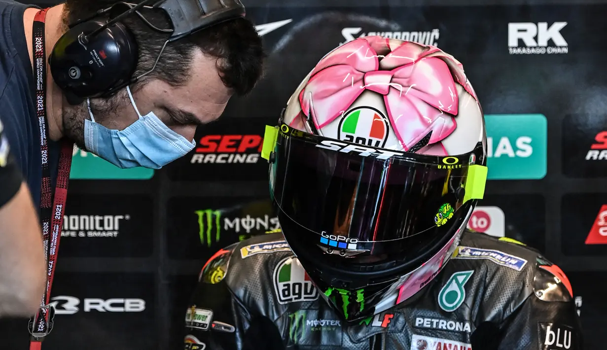 Helm yang didesain oleh Aldo Drudi ini begitu kental dengan aura perempuan. Pebalap juara dunia 9 kali ini memasukkan unsur feminim seperti grafis pita dan warna pink. (AFP/Andreas Solaro)