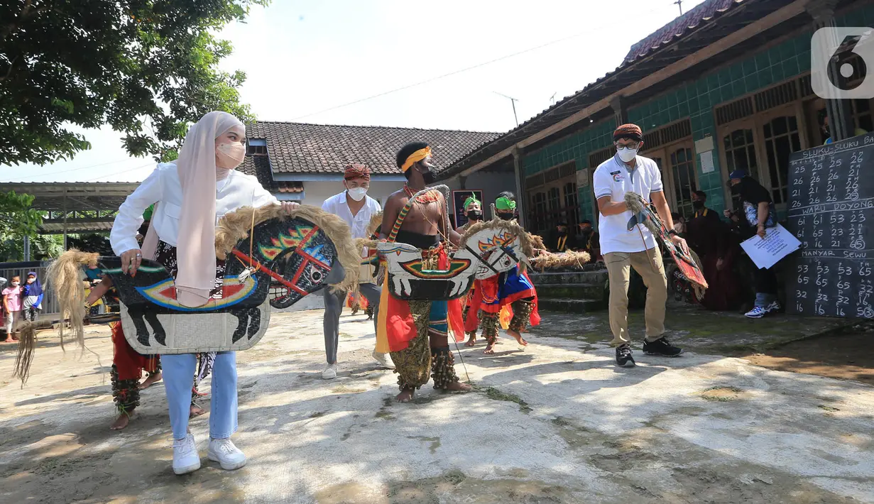 <p>Menteri Pariwisata dan Ekonomi Kreatif (Menparekraf) Sandiaga Salahudin Uno (kanan), youtuber Mitty Zasia dan public figur Ananda Omesh (Omesh) menari jathilan di desa wisata Candirejo, Kabupaten Magelang, Jawa Tengah, Jumat (4/6/2021). (Liputan6.com/HO/Kemenparekraf)</p>