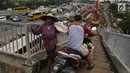 Pengendara motor melintas di samping pejalan kaki menuruni Jembatan Penyeberangan Orang (JPO) kawasan Cikunir, Bekasi Barat, Senin (12/3). Di jembatan ini pejalan kaki dan pemotor saling berebut melintas. (Liputan6.com/Arya Manggala)