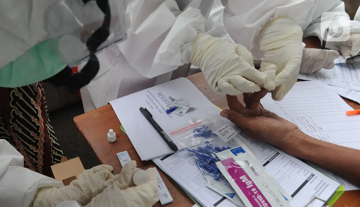 Paramedis mengambil sampel penumpang KRL Commuter Line saat tes swab di Stasiun Bojonggeder, Jawa Barat, Senin (11/05/2020).  Pemkab Bogor  melakukan tes swab  dan rapid test bagi penumpang KRL Commuter Line  dilakukan secara massal. (merdeka.com/Arie Basuki)