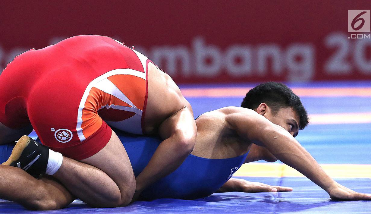 Pegulat putra Indonesia, Muhammad Aliansyah saat bertarung melawan pegulat Korea Utara Kim Myong Chol pada kelas putra 67 Kg di arena gulat JCC Senayan, Selasa (21/8). (Liputan6.com/Fery Pradolo)