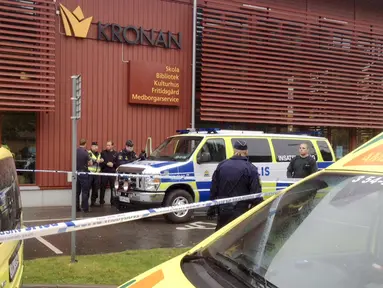 Petugas memasang garis polisi di sekolah Kronan di Trollhattan, Swedia barat, Kamis (22/10). Seorang pria bertopeng dan bersenjatakan pedang menyerang sekolah tersebut dan menewaskan satu murid dan satu guru. (REUTERS/Stig Hedstrom/TT News Agency)