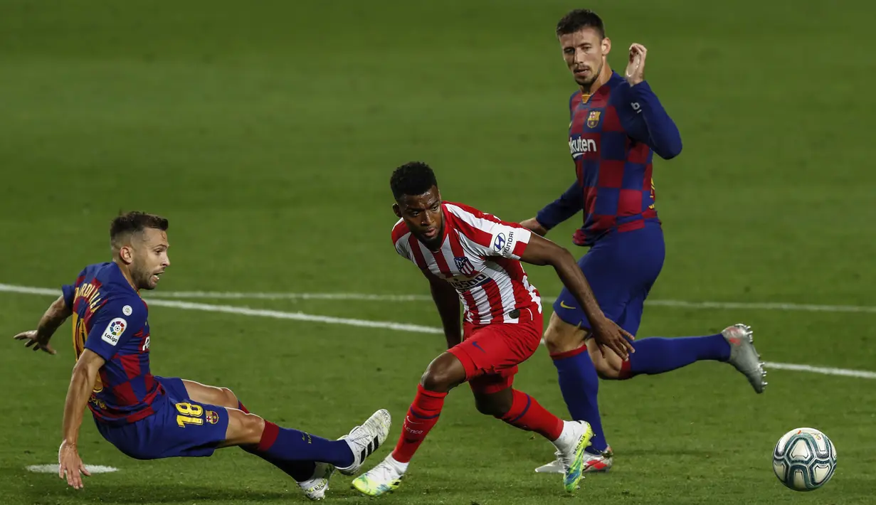 Pemain Atletico Madrid Thomas Lemar (tengah) mencoba melewati pemain Barcelona Jordi Alba (kiri) dan Clement Lenglet (kanan) pada pertandingan La Liga di Stadion Camp Nou, Barcelona, Spanyol, Selasa (30/6/2020). Barcelona bermain imbang 2-2 melawan Atletico Madrid. (AP Photo/Joan Monfort)