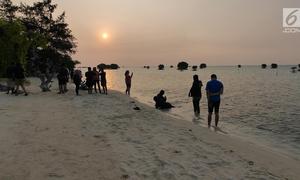 Warga menyaksikan matahari tenggelam (sunset) di Pulau Pari, Kepulauan Seribu, Jakarta pada 3 Agustus 2019. Pulau Pari mempunyai keindahan saat matahari terbenam yang dapat dilihat dari Tanjung Renggae. (Liputan6.com/Herman Zakharia)
