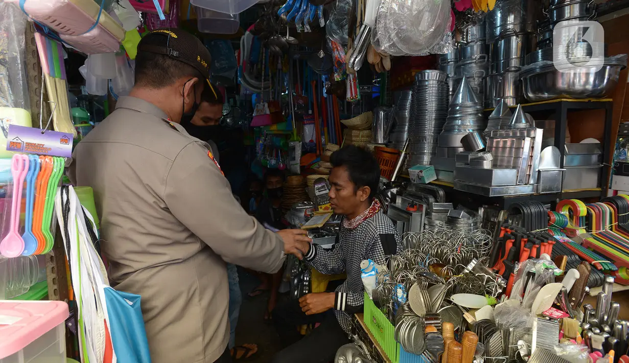 Petugas membagikan masker kepada warga di Pasar Jatinegara, Kamis (10/9/2020). Pembagian masker serta himbauan  memakai masker saat keluar rumah dan ditempat Himb ini dilakukan untuk pencegahan penularan Covid-19 dimana kasus Covid-19 terus meningkat. (merdeka.com/Imam Buhori)