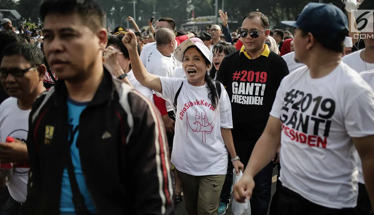 Massa berkaus #2019GantiPresiden meneriakan yel-yel ganti presiden ketika bertemu massa berkaus #DiaSibukKerja pada Car Free Day di Bundaran HI, Jakarta, Minggu (29/4). Saling sindir tak terelakan saat kedua aksi ini bertemu. (Liputan6.com/Faizal Fanani)