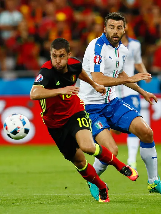 Gelandang Belgia, Eden Hazard (kiri) berusaha mengejar bola dari kawalan bek Italia, Andrea Barzagli pada pertandingan grup E Piala Eropa di Stade de Lyon, Prancis, (14/6). Italia menang atas Belgia dengan skor 2-0. (REUTERS/Jason Cairnduff)