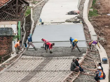 Pekerja menyelesaikan pembangunan jalan Inspeksi di kawasan kali Ciliwung Kalibata, Jakarta, Rabu (30/11). Proyek tersebut selain dapat mempermudah normalisasi sungai serta dapat menjadi alternatif bagi pengguna jalan.  (Liputan6.com/Gempur M Surya)