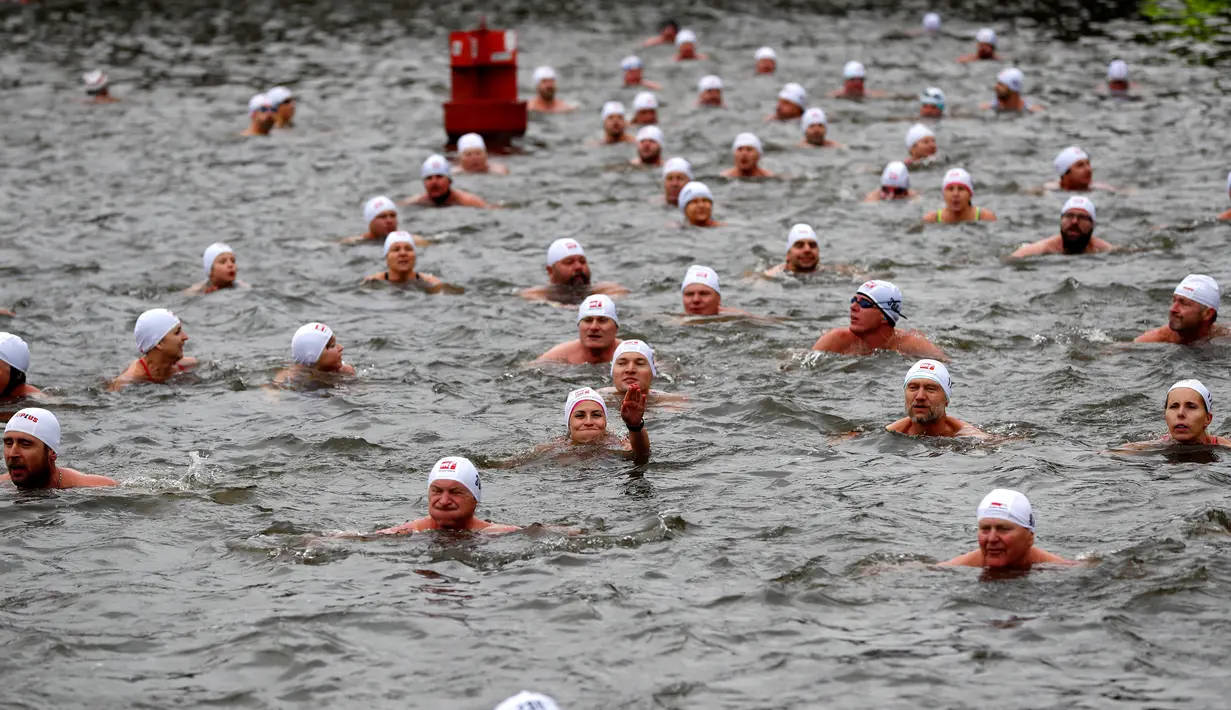Orang-orang mengambil bagian dalam kompetisi berenang Natal tahunan di sungai Vltava, ibu kota Republik ceko, Praha, Rabu (26/12). Dalam menyemarakkan Natal, para peserta mengikuti lomba renang di sungai bersuhu dingin. (AP/Petr David Josek)