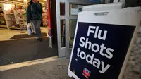 Sebuah papan pengumuman yang menginformasikan ketersediaan vaksinasi flu dipasang di luar toko obat CVS di New York, Amerika Serikat, pada 15 Januari 2013. (Xinhua/Wang Lei)