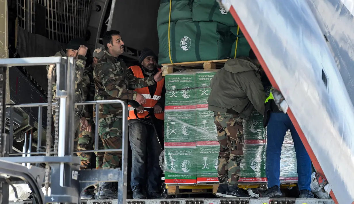 Sejumlah paket bantuan kemanusiaan yang disediakan oleh Arab Saudi untuk para korban gempa bumi Turki dan Suriah diturunkan dari pesawat angkut Ilyushin Il-76TD di Bandara Internasional Aleppo, Suriah Utara, Selasa (14/2/2023). Sepekan pasca-gempa, jumlah korban jiwa merangkak naik hingga di atas 33 ribu orang dan diperkirakan akan terus bertambah. (AFP)