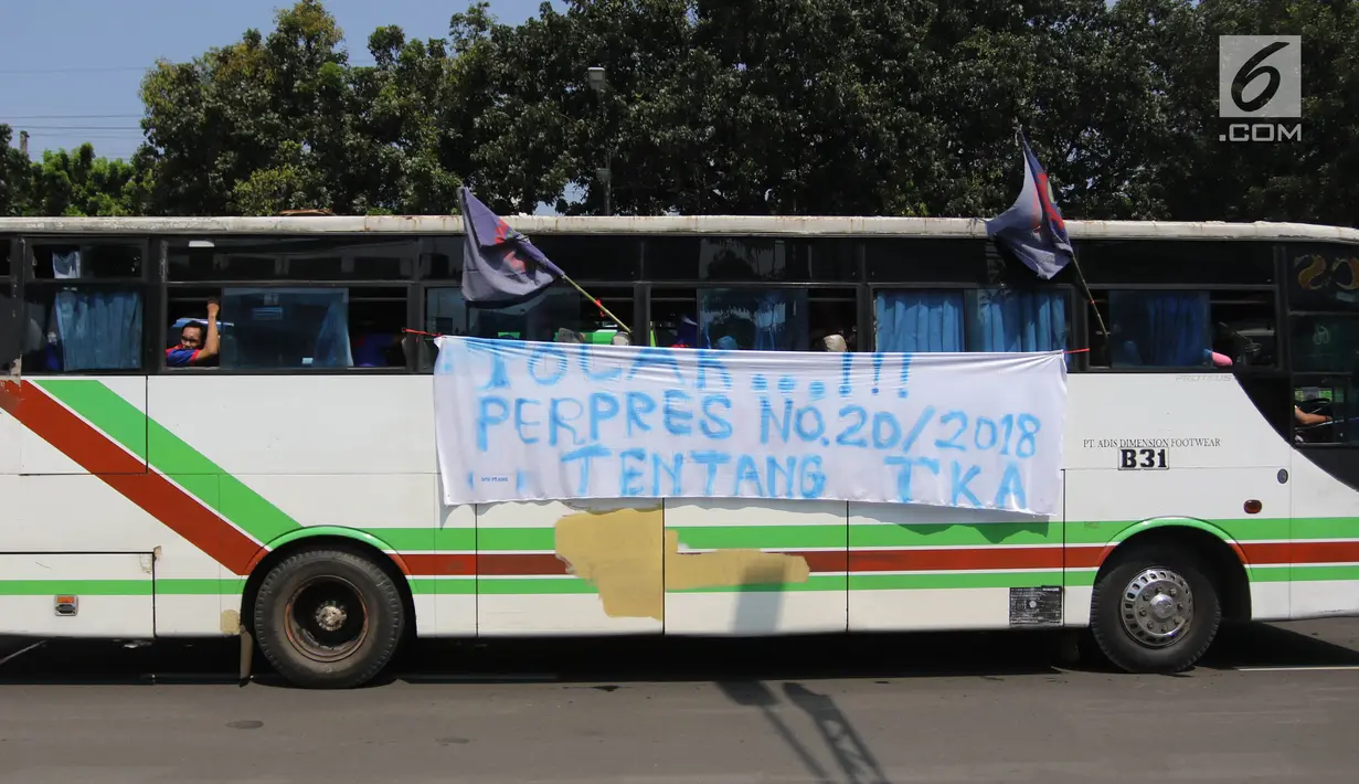 Sebuah spanduk terpampang di bus yang mengangkut buruh saat melakukan aksi May Day 2018 di Jalan Medan Merdeka Timur, Jakarta, Selasa (1/5). (Liputan6.com/Arya Manggala)
