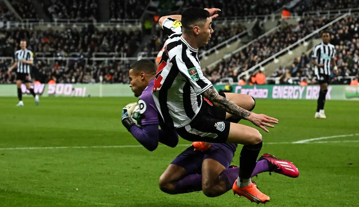 Pemain Newcastle United Miguel Almiron (depan kanan) berebut bola dengan kiper Southampton Gavin Bazunu pada pertandingan sepak bola semifinal Piala Liga Inggris di Stadion St James's Park, Newcastle, Inggris, 31 Januari 2023. Newcastle United mengalahkan Southampton dengan skor 2-1 dan berhasil melenggang ke final Piala Liga Inggris. (Paul ELLIS/AFP)
