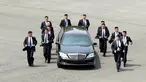 Para pengawal berlari di samping mobil yang membawa Pemimpin Korea Utara Kim Jong-un saat akan makan siang dalam KTT Korea Selatan-Korea Utara di zona demiliterisasi, Panmunjom, Korea Selatan, Jumat (27/4). (Korea Summit Press Pool/AFP)