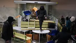 Pendukung rapper Pablo Hasel membuat barikade di dalam Universitas Lleida, Spanyol, Senin (15/2/2021). Pablo Hasel bersama sekitar 20 pendukungnya menggunakan rantai dengan gembok untuk menutup pintu masuk utama ke salah satu gedung Universitas Lleida. (AP Photo/Joan Mateu)