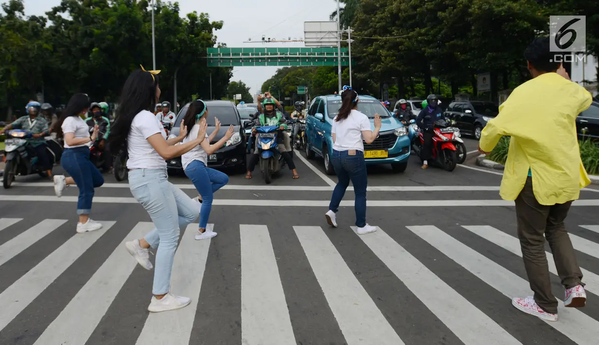 Sejumlah mahasiswa dan mahasiswi menari saat mengampanyekan keselamatan berlalu lintas di Jakarta, Rabu (20/3). Aksi ini mengajak pengendara untuk tertib berlalu lintas dengan #SelamatDijalan. (merdeka.com/Imam Buhori)