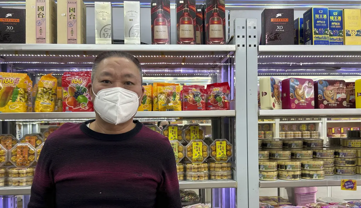 Pemilik toko suvenir Lee Hong-soi berdiri di tokonya di Makau pada 28 Desember 2022. Dia mengatakan bisnisnya menjadi lebih sepi akhir-akhir ini daripada sebelum aturan masuk dilonggarkan. Karena masuk ke Makau memerlukan hasil tes PCR negatif sebelum keberangkatan, banyak orang di China daratan tidak dapat berkunjung karena terinfeksi, katanya. (AP Photo/Kanis Leung)