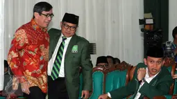 Ketua Umum PKB Muhaimin Iskandar (kedua kiri) memeluk Menkumham Yasonna Laoly (kiri) disaksikan Sekjen PKB Abdul Kadir Karding dalam peringatan hari lahir ke-18 Partai Kebangkitan Bangsa di DPP PKB Jakarta, Sabtu (23/7). (Liputan6.com/Helmi Afandi)