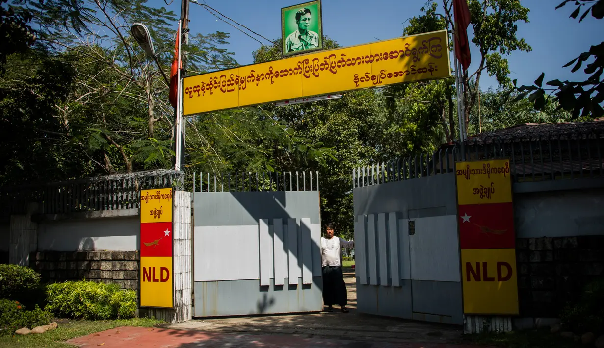 Seorang pria menutup gerbang rumah pemimpin Myanmar, Aung San Suu Kyi setelah dilempar bom Molotov di pinggir danau di Yangon, Kamis (1/2). Juru bicara pemerintah Myanmar tidak memberikan penjelasan lebih detail mengenai insiden tersebut (YE AUNG THU/AFP)
