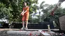 Seorang anak menaburkan bunga ke makam saat ziarah di kompleks pemakaman Gereja Tugu, Semper, Jakarta, Senin (23/12/2019). Ziarah menjadi tradisi keluarga keturunan Portugis di Kampung Tugu menjelang Hari Raya Natal. (merdeka.com/Iqbal Nugroho)