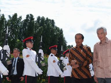 Perdana Menteri Singapura Lee Hsien Loong (kanan) menyambut Presiden Indonesia Joko Widodo atau Jokowi di Istana Kepresidenan Singapura, Singapura, Kamis (16/3/2023). (EDGAR SU/POOL/AFP)